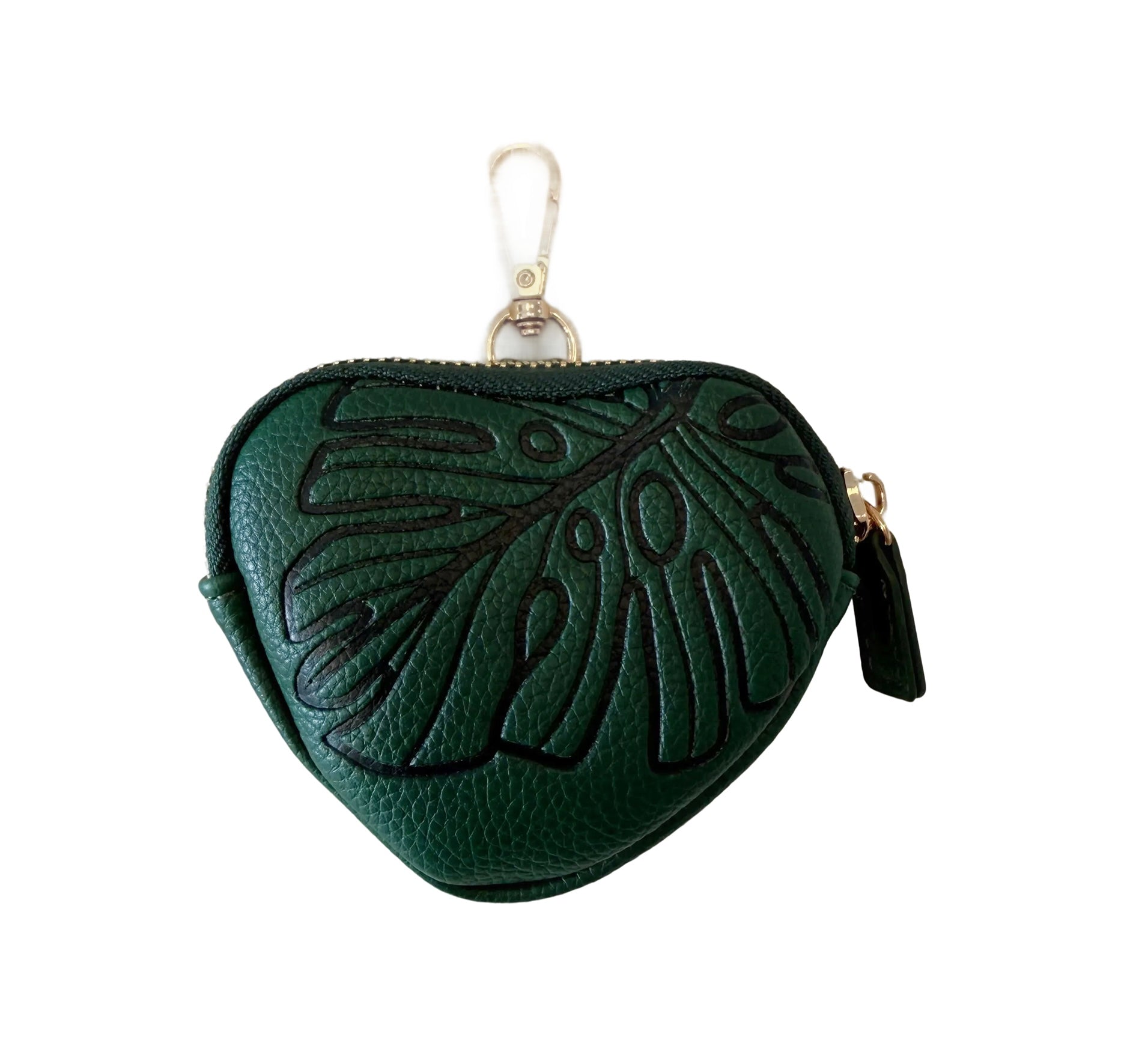 small heart shaped pouch in the color emerald featuring the front of pouch with a monstera leaf design, a gold zipper and gold claps at the top.